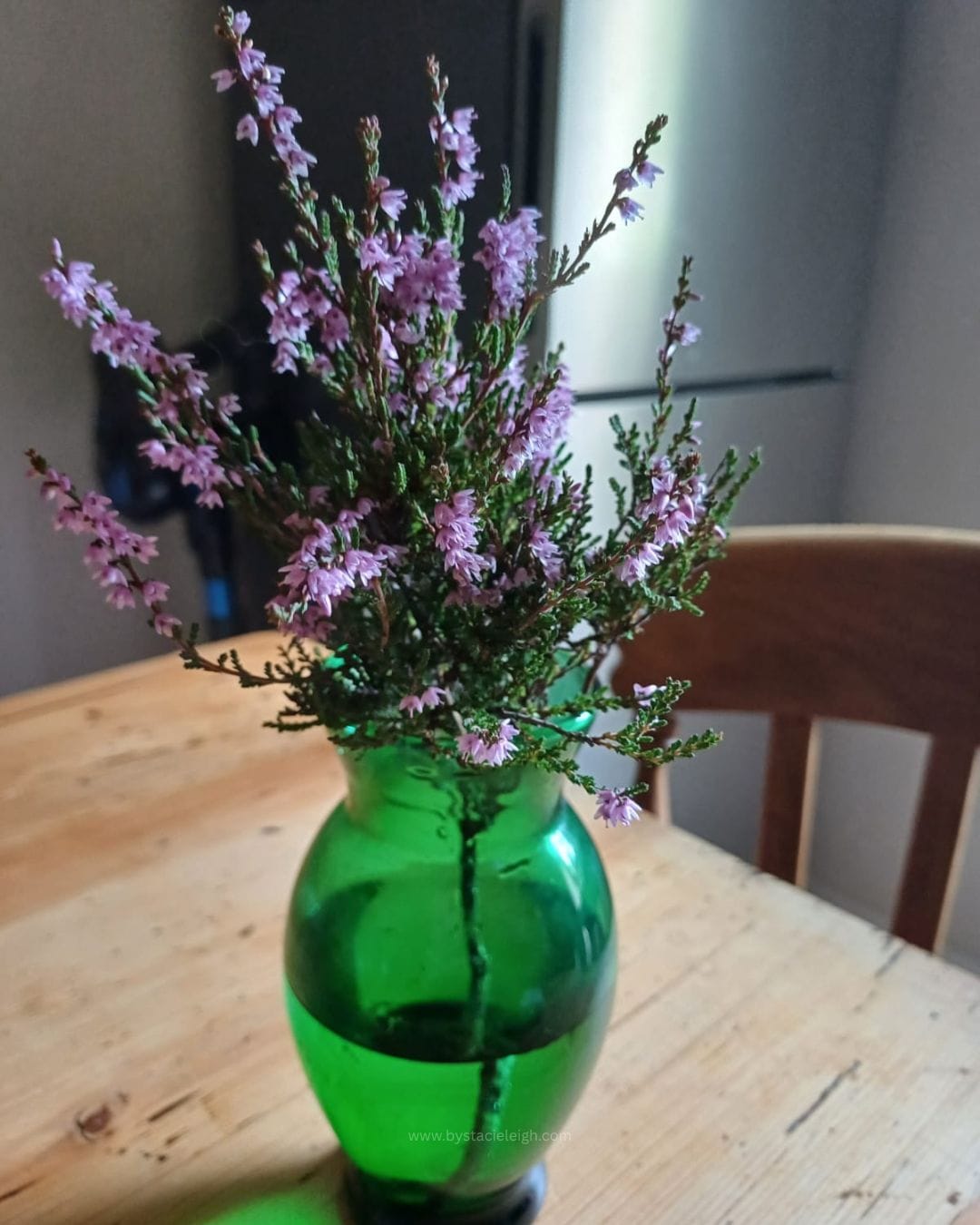 heathers in a green glass vase
